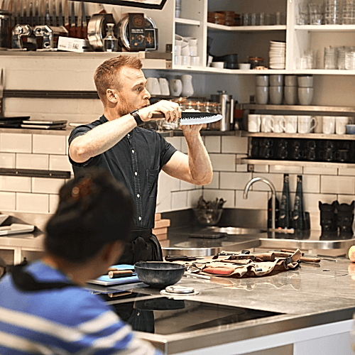 Student practicing knife skills at Avenue Cookery School in London
